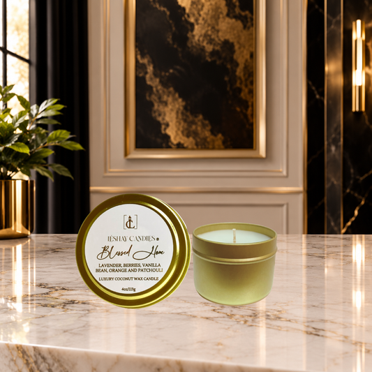 A luxury Blessed Home candle by LéShay Candles shown in an elegant interior setting. The product features a round gold metal tin with a white and gold label sitting on a marble countertop.